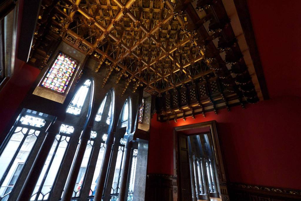 Techo artesonado de madera y ventanales de la galería del primer piso del Palacio Güell de Gaudí, Barcelona